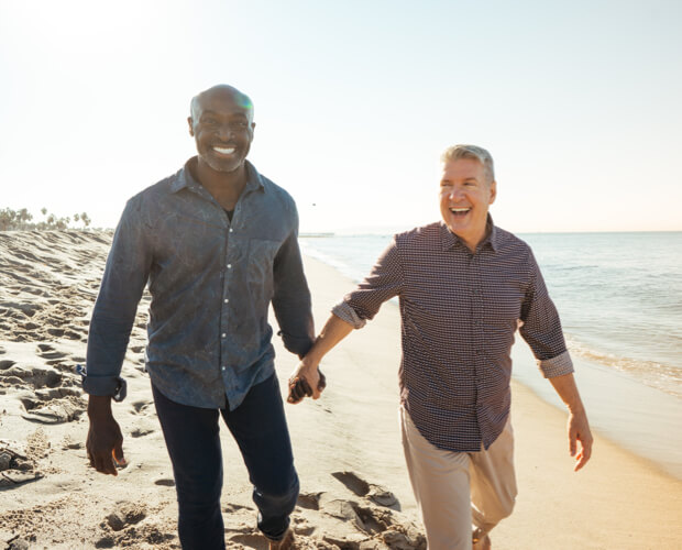 Two men holding hands at a beach